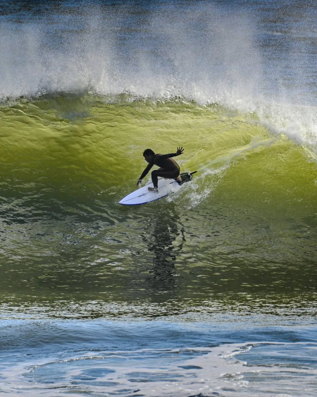 Surfista dentro de um tubo verde sob céu azul